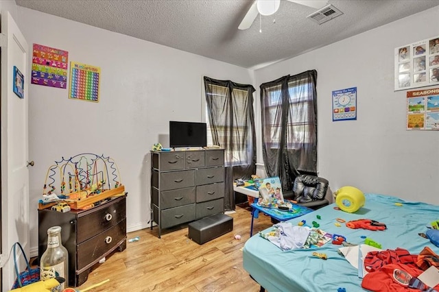 2119 Pearson Dr, Midwest City, OK 73110 - bedroom featuring light wood finished floors, a textured ceiling, and ceiling fan
