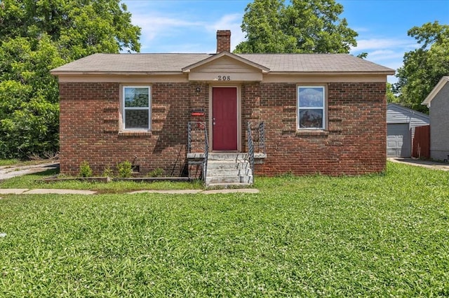 208 E Lockheed Dr, Midwest City, OK 73110 - view of front facade featuring a front lawn, a chimney, brick siding, an outbuilding, and a garage