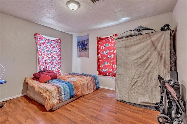 208 E Lockheed Dr, Midwest City, OK 73110 - bedroom featuring wood finished floors and a textured ceiling