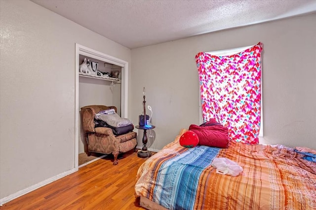 208 E Lockheed Dr, Midwest City, OK 73110 - bedroom featuring wood finished floors, a textured ceiling, and a closet