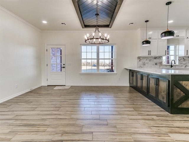 26603 Main St, Blanchard, OK 73010 - kitchen with a chandelier, light countertops, white cabinetry, light wood-style floors, and baseboards