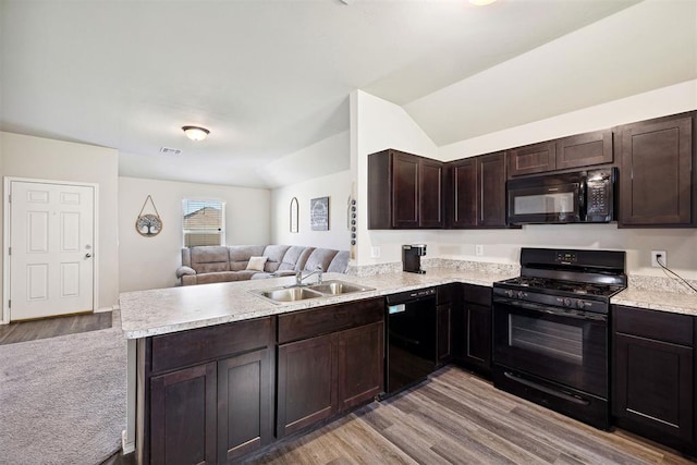 11604 NW 95th St, Yukon, OK 73099 - kitchen with black appliances, open floor plan, a peninsula, light wood finished floors, and light countertops