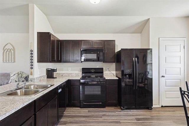 11604 NW 95th St, Yukon, OK 73099 - kitchen with black appliances, light wood finished floors, dark brown cabinets, and light countertops