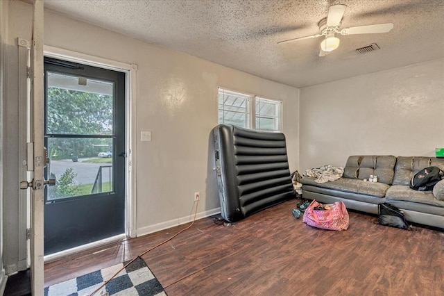 1500 Maple Dr, Midwest City, OK 73110 - living area featuring a textured ceiling, wood finished floors, and a ceiling fan