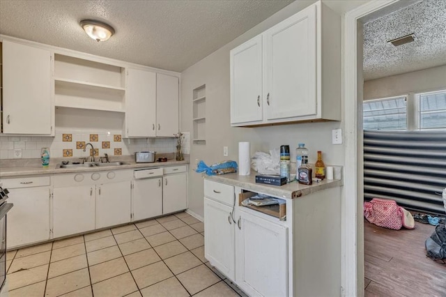 1500 Maple Dr, Midwest City, OK 73110 - kitchen featuring a textured ceiling, dishwasher, open shelves, light countertops, and white cabinets