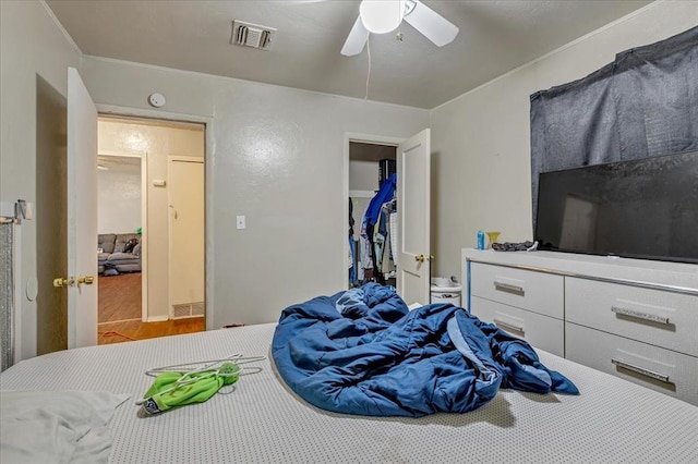 1500 Maple Dr, Midwest City, OK 73110 - bedroom with wood finished floors, ceiling fan, a closet, a walk in closet, and crown molding