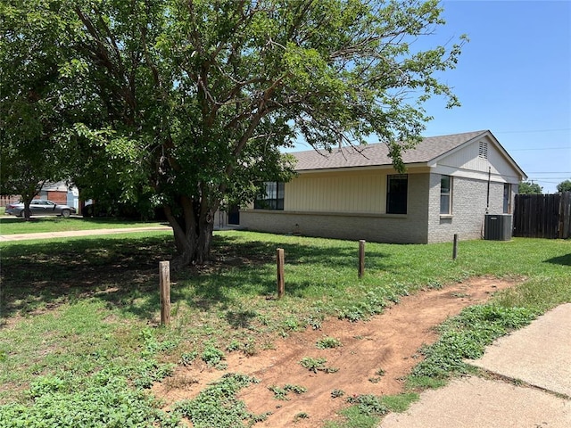 1012 Box St, Altus, OK 73521 - view of side of home featuring brick siding, central air condition unit, and roof with shingles