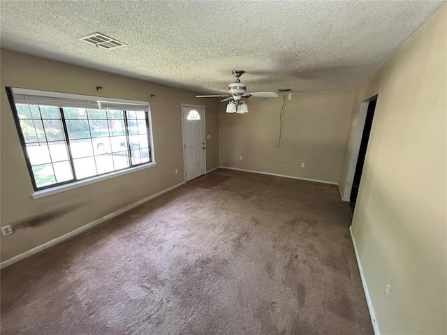 1012 Box St, Altus, OK 73521 - unfurnished living room with a ceiling fan, a textured ceiling, carpet, and baseboards