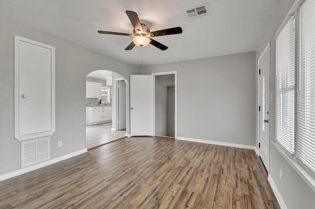 724 SW 48th St, Oklahoma City, OK 73109 - unfurnished bedroom with arched walkways, wood finished floors, baseboards, and a ceiling fan