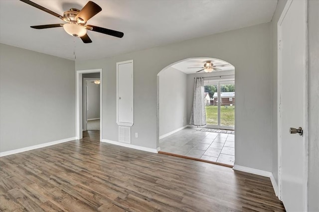 724 SW 48th St, Oklahoma City, OK 73109 - empty room with arched walkways, ceiling fan, baseboards, and wood finished floors