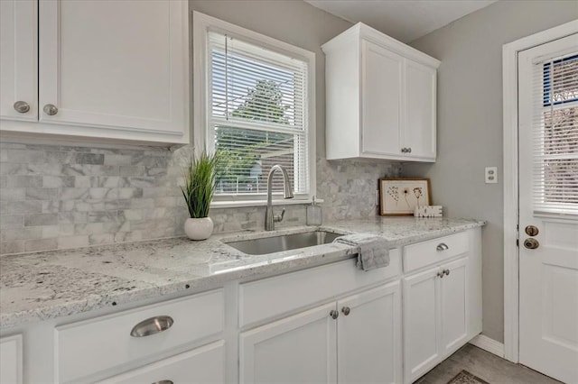 724 SW 48th St, Oklahoma City, OK 73109 - kitchen featuring a sink, healthy amount of natural light, white cabinetry, and backsplash