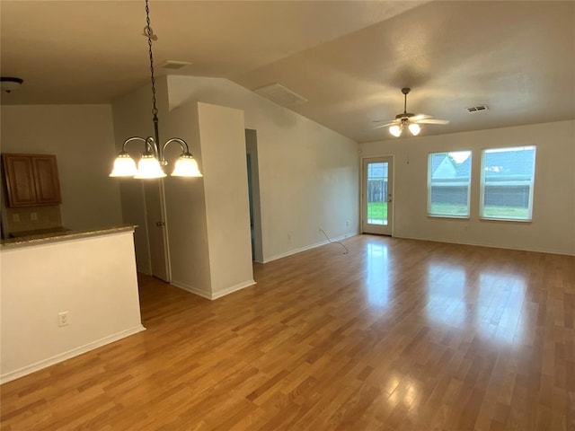 1817 NW 146th St, Edmond, OK 73013 - unfurnished living room with light wood-style flooring, vaulted ceiling, ceiling fan, baseboards, and a chandelier