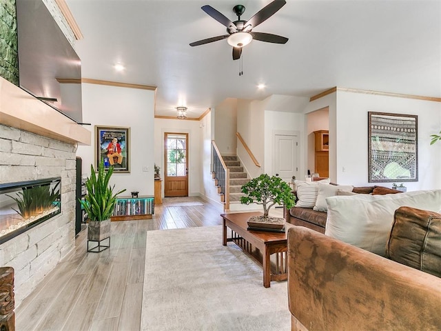 13001 Broken Arrow, Arcadia, OK 73007 - living area with ornamental molding, stairs, a ceiling fan, light wood-style flooring, and a stone fireplace