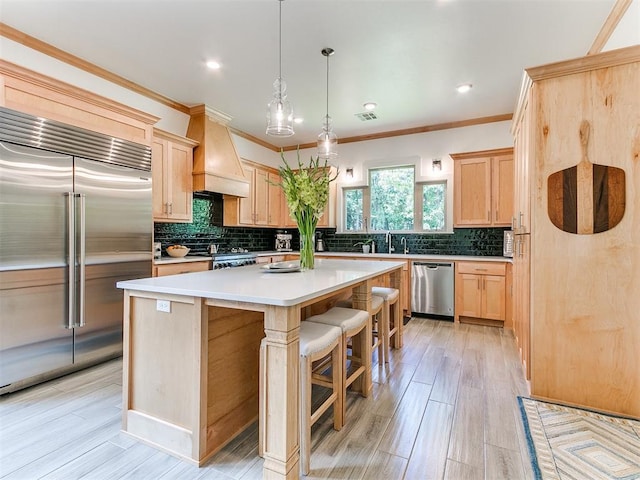 13001 Broken Arrow, Arcadia, OK 73007 - kitchen with stainless steel appliances, light brown cabinets, custom range hood, a kitchen island, and tasteful backsplash
