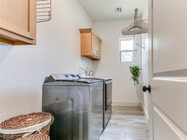 13001 Broken Arrow, Arcadia, OK 73007 - washroom with washing machine and dryer, cabinet space, light wood-style flooring, and baseboards