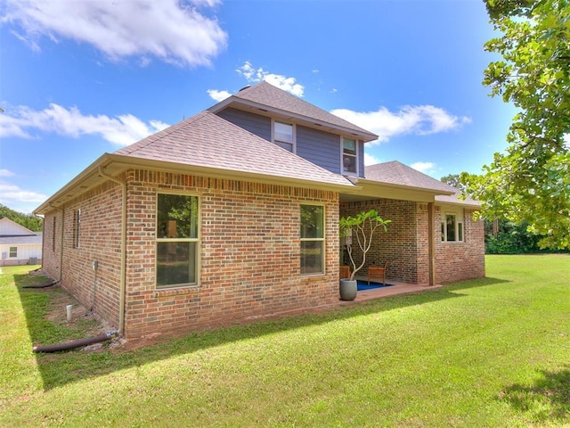 13001 Broken Arrow, Arcadia, OK 73007 - rear view of property featuring roof with shingles, a yard, brick siding, and a patio area