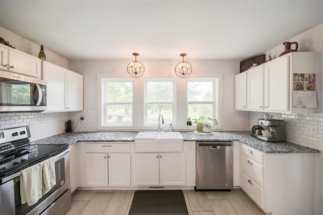 4120 SE 112th St, Moore, OK 73160 - kitchen featuring appliances with stainless steel finishes, a sink, white cabinetry, and light stone counters
