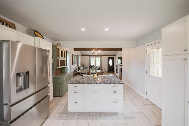 4120 SE 112th St, Moore, OK 73160 - kitchen featuring stainless steel refrigerator with ice dispenser, dark stone counters, a chandelier, a kitchen island, and white cabinetry
