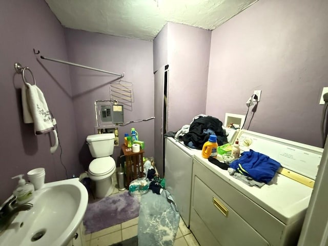 1410 W Warner Ave, Guthrie, OK 73044 - bathroom with independent washer and dryer, a sink, toilet, and tile patterned floors