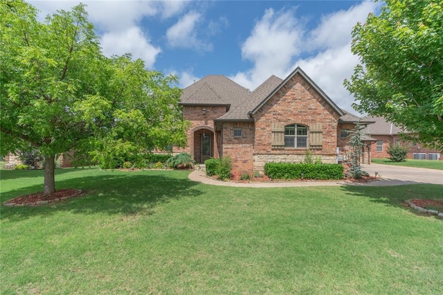2017 Pembroke Ln, Edmond, OK 73003 - view of front of property featuring brick siding, a front yard, roof with shingles, stone siding, and driveway