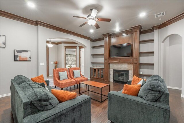 2017 Pembroke Ln, Edmond, OK 73003 - living room with arched walkways, crown molding, ceiling fan, baseboards, and dark wood-style floors