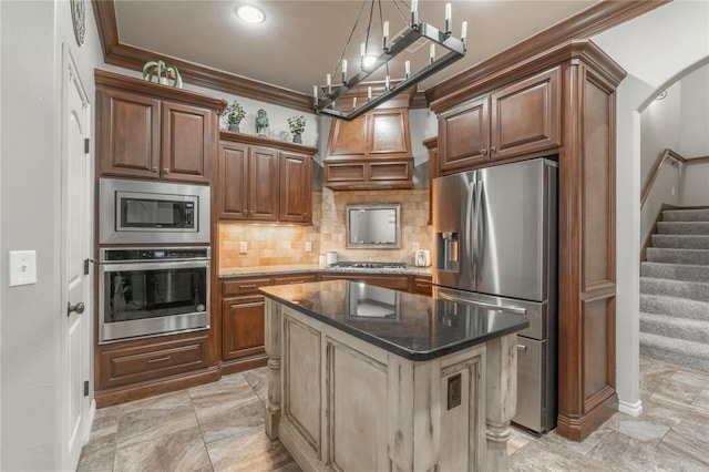 2017 Pembroke Ln, Edmond, OK 73003 - kitchen with stainless steel appliances, decorative backsplash, ornamental molding, dark stone counters, and a kitchen island