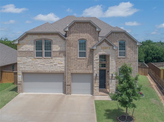 1417 Cordgrass Ct, Edmond, OK 73013 - french country home with stone siding, concrete driveway, an attached garage, brick siding, and a shingled roof