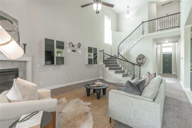 1417 Cordgrass Ct, Edmond, OK 73013 - living area featuring a high ceiling, plenty of natural light, stairs, a ceiling fan, and a tiled fireplace