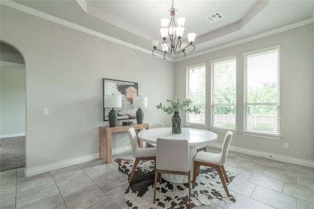 1417 Cordgrass Ct, Edmond, OK 73013 - dining area with a chandelier, a raised ceiling, baseboards, ornamental molding, and arched walkways