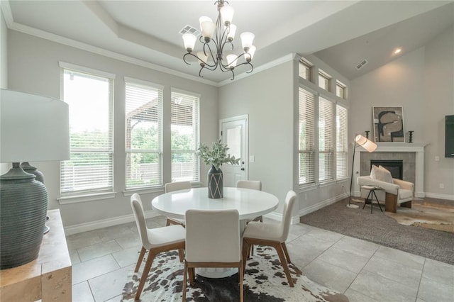 1417 Cordgrass Ct, Edmond, OK 73013 - dining room with healthy amount of natural light, baseboards, a tile fireplace, a chandelier, and crown molding