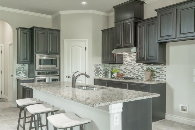 1417 Cordgrass Ct, Edmond, OK 73013 - kitchen with stainless steel appliances, a sink, light stone countertops, a breakfast bar area, and tasteful backsplash