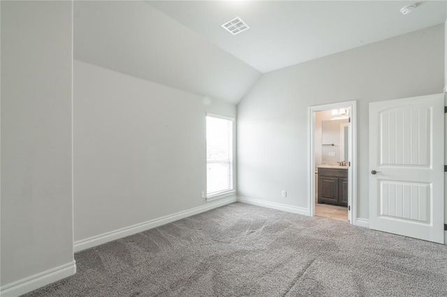 1417 Cordgrass Ct, Edmond, OK 73013 - unfurnished bedroom featuring lofted ceiling, baseboards, light colored carpet, and ensuite bathroom