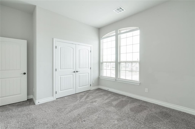 1417 Cordgrass Ct, Edmond, OK 73013 - unfurnished bedroom featuring carpet floors, multiple windows, baseboards, and a closet