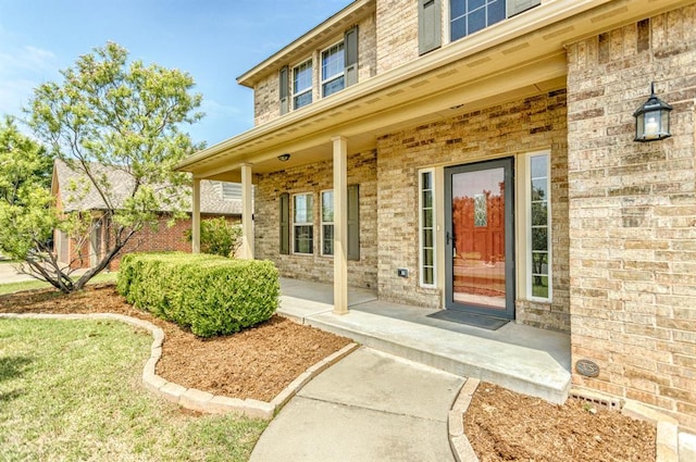 17504 Silverhawk Way, Edmond, OK 73012 - view of exterior entry with a porch and brick siding