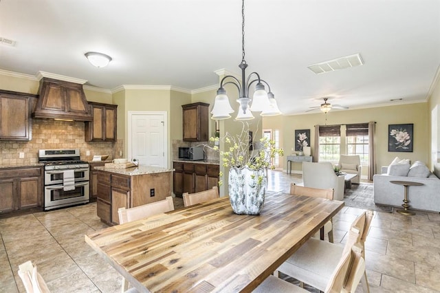 17504 Silverhawk Way, Edmond, OK 73012 - dining area with crown molding, ceiling fan, a chandelier, and light tile patterned flooring