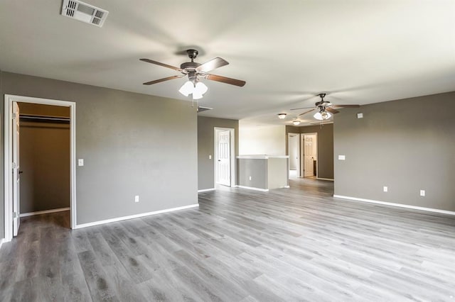 17504 Silverhawk Way, Edmond, OK 73012 - unfurnished living room with ceiling fan, baseboards, and wood finished floors