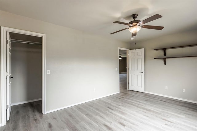 17504 Silverhawk Way, Edmond, OK 73012 - unfurnished bedroom featuring a walk in closet, wood finished floors, baseboards, and a closet