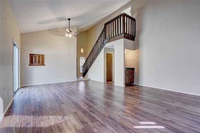 12217 Cork Rd, Oklahoma City, OK 73162 - unfurnished living room with stairway, ceiling fan, wood finished floors, and high vaulted ceiling