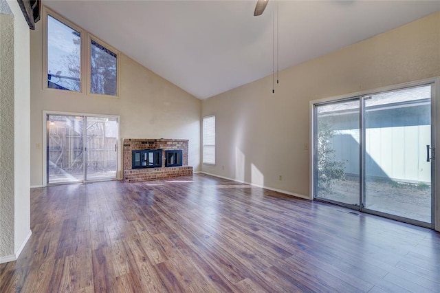 12217 Cork Rd, Oklahoma City, OK 73162 - unfurnished living room with wood finished floors, high vaulted ceiling, ceiling fan, and a brick fireplace