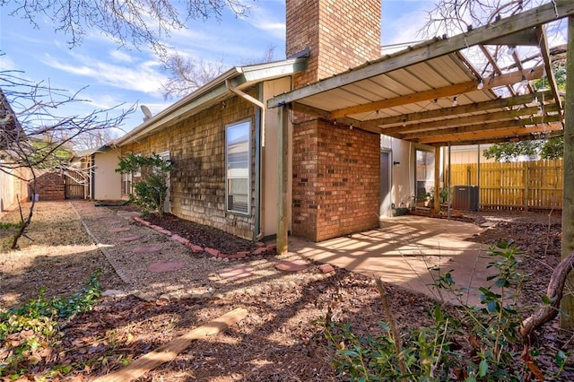 12217 Cork Rd, Oklahoma City, OK 73162 - view of side of property featuring a chimney, a patio area, and brick siding