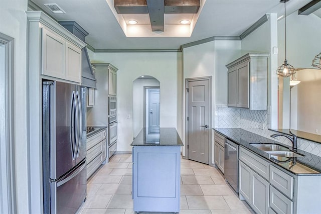3024 Wakefield Rd, Edmond, OK 73034 - kitchen with stainless steel appliances, arched walkways, decorative backsplash, dark stone countertops, and a center island