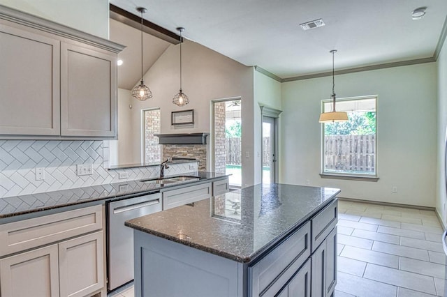 3024 Wakefield Rd, Edmond, OK 73034 - kitchen with stainless steel dishwasher, tasteful backsplash, a center island, dark stone countertops, and vaulted ceiling