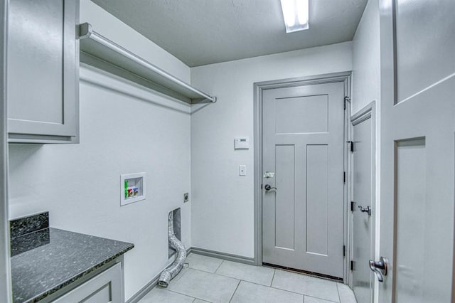 3024 Wakefield Rd, Edmond, OK 73034 - laundry area featuring electric dryer hookup, washer hookup, light tile patterned floors, and cabinet space