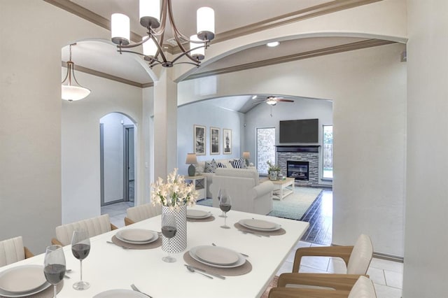 3024 Wakefield Rd, Edmond, OK 73034 - dining space with arched walkways, lofted ceiling, a ceiling fan, a fireplace, and ornamental molding