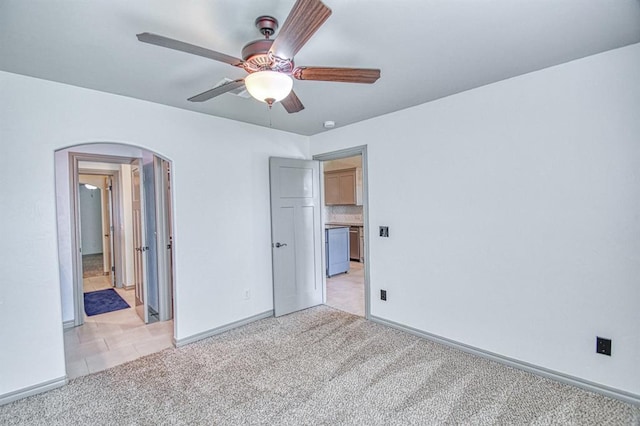 3024 Wakefield Rd, Edmond, OK 73034 - unfurnished bedroom featuring arched walkways, light carpet, and ceiling fan