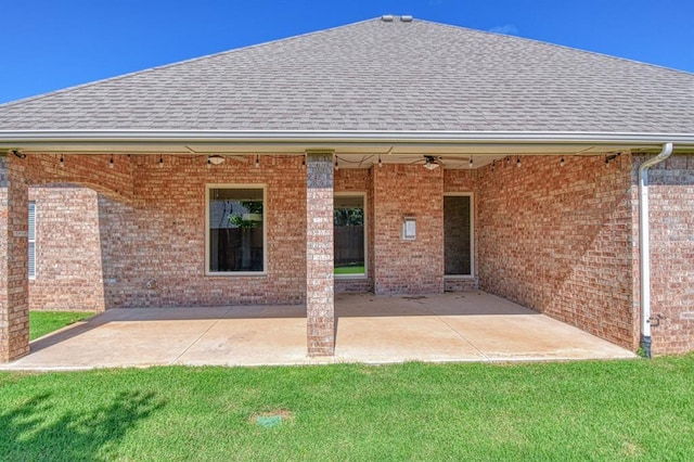 3024 Wakefield Rd, Edmond, OK 73034 - rear view of house with roof with shingles, brick siding, ceiling fan, and a patio area