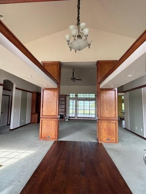 1608 Bentwater Dr, Kingfisher, OK 73750 - unfurnished living room featuring wood finished floors, a chandelier, a high ceiling, ceiling fan, and carpet