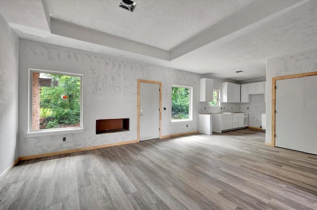 2807 N Lyon Dr, Oklahoma City, OK 73107 - unfurnished living room with light wood finished floors, a fireplace, baseboards, and a raised ceiling