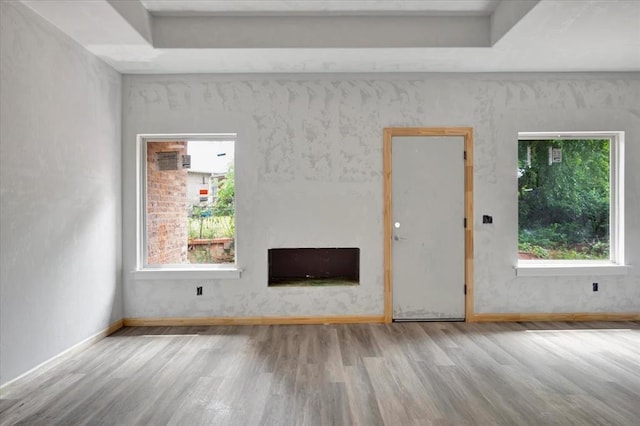 2807 N Lyon Dr, Oklahoma City, OK 73107 - unfurnished living room featuring wood finished floors, plenty of natural light, and baseboards