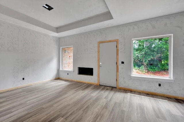 2807 N Lyon Dr, Oklahoma City, OK 73107 - empty room featuring wood finished floors, a tray ceiling, baseboards, and a fireplace